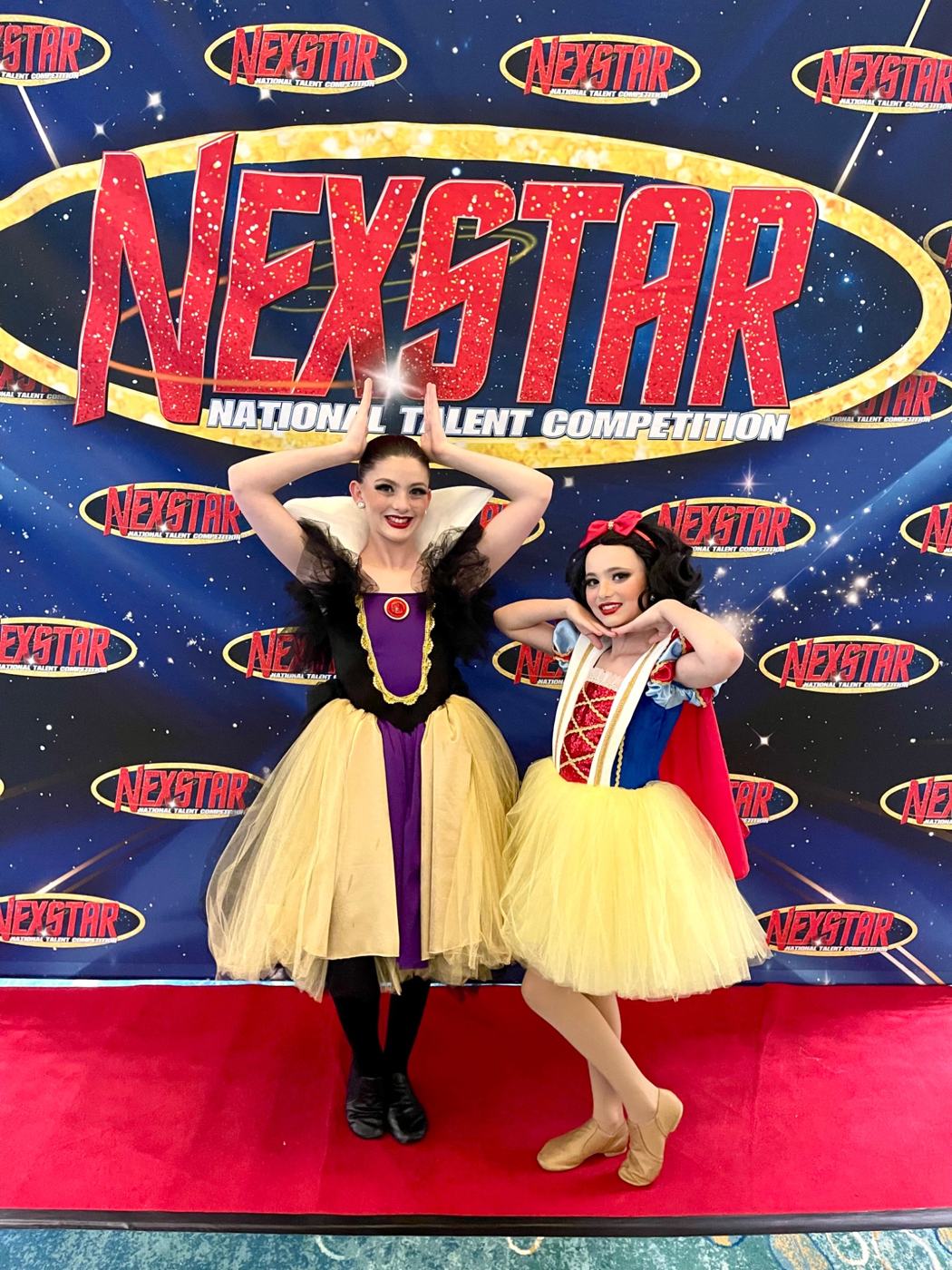 The sisters smiling together in their dance costumes